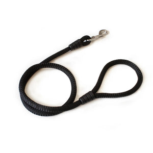 Correa negra para perro de nylon resistente con mosquetón metálico sobre fondo blanco.